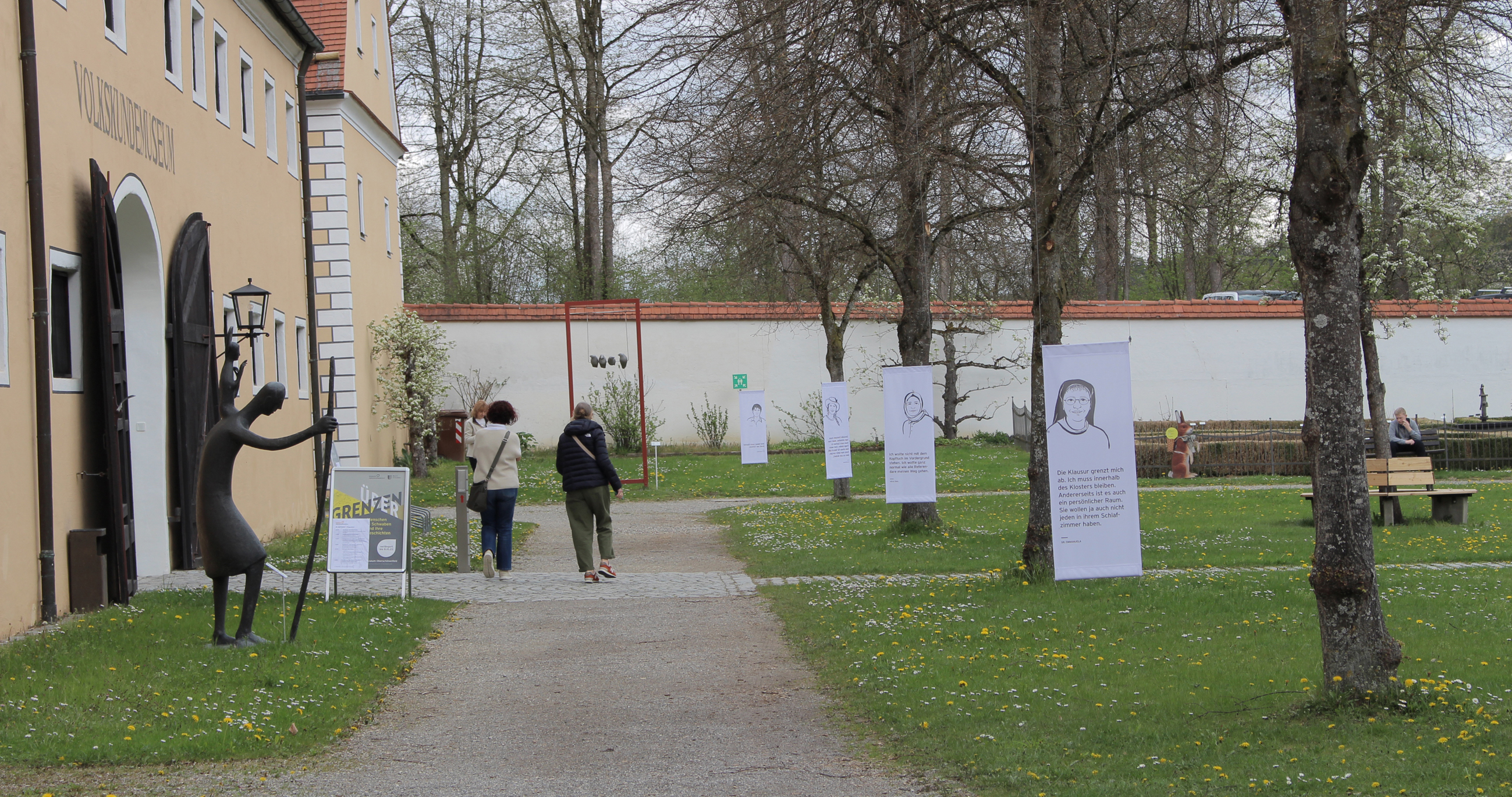 Bäume mit weißen Fahnen mit Portraits der Ausstellungs-Protagonisten
