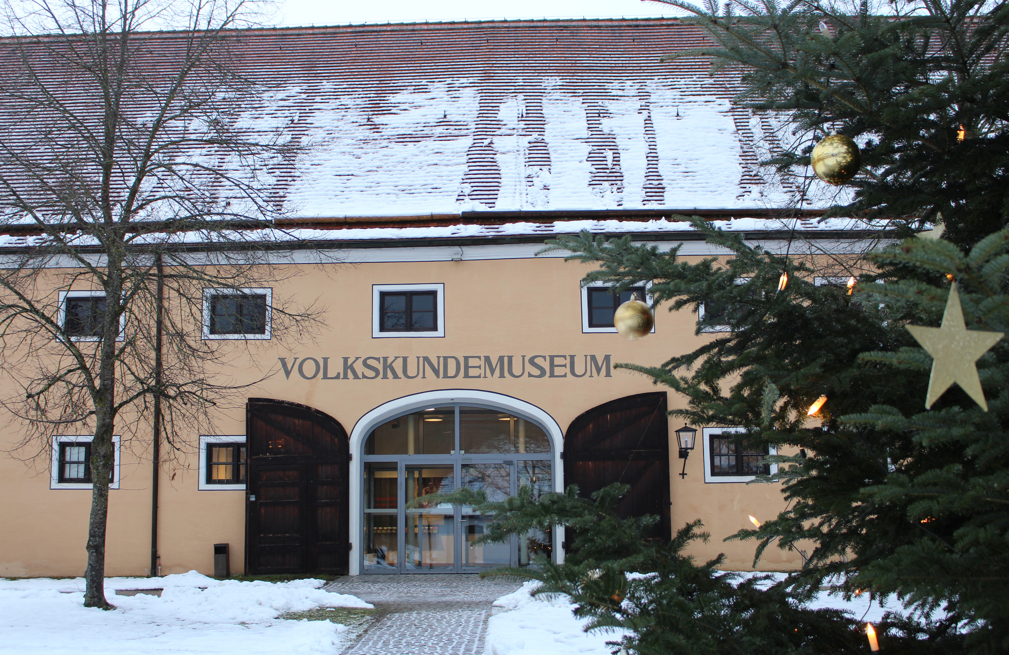 Museumseingang mit Schnee und Baum