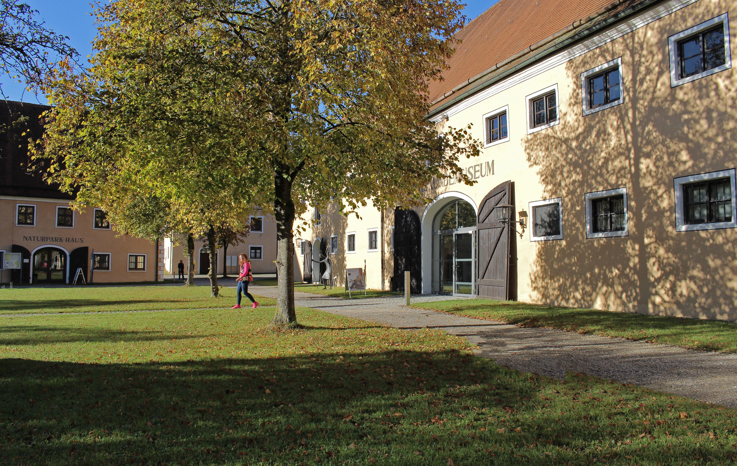 Museumseingang neben Baum mit buntem Herbstlaub