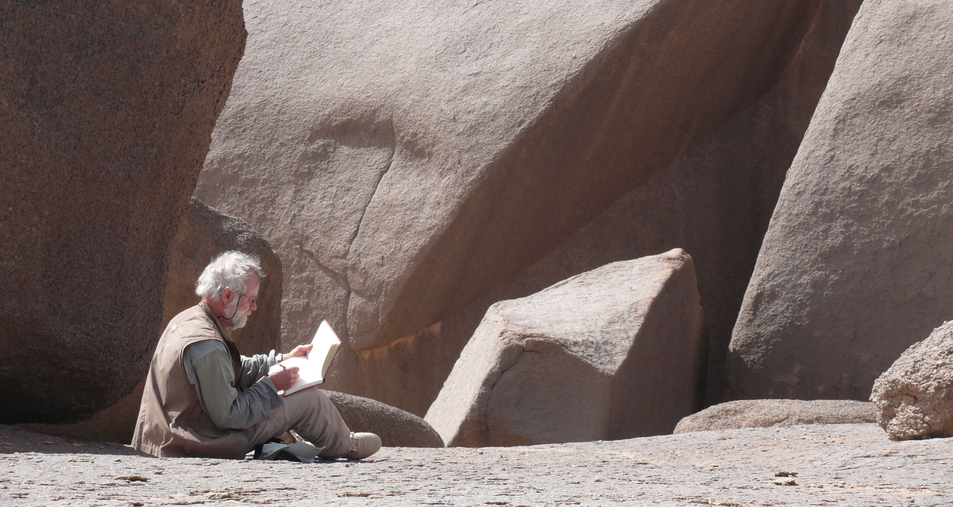 Hartmut Pfeuffer skizziert sitzend einen Felsen 