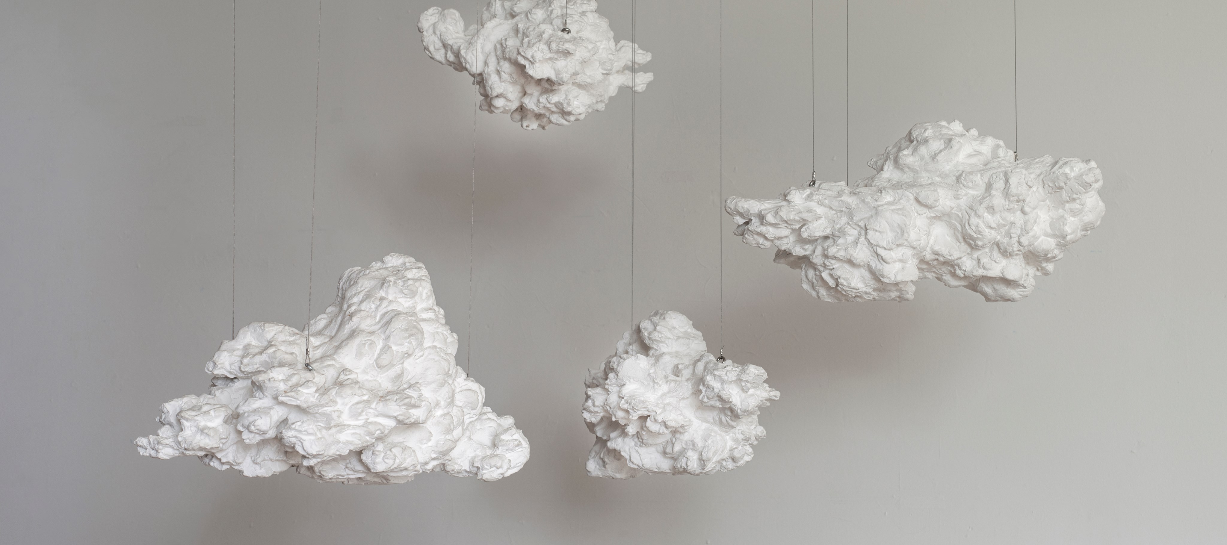 Vier Skulpturen als hängende Wolken aus Gips