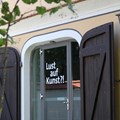  Großes Holztor umrahmt Glastüre mit Aufschrift "Lust auf Kunst" 