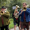 Gruppe von marschierenden Blasmusikern und Musikerinnen in Tracht