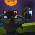 Wie entsteht ein Ton? Besucherin mit Kopfhörer