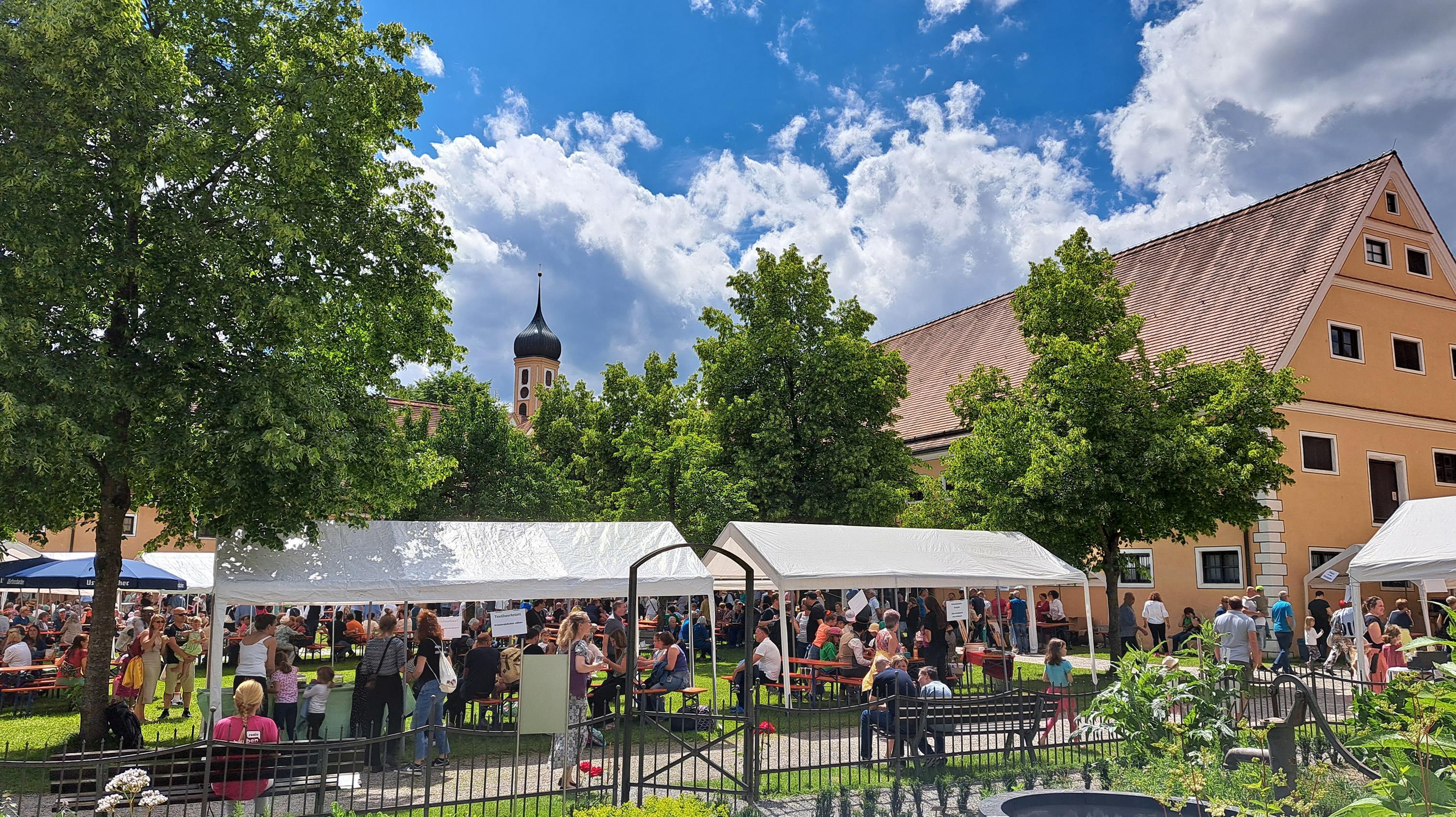 Museumshof mit Pavillons und feiernden Besuchern
