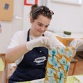 Junge Frau zieht Papier mit Marmormuster aus einer Schale