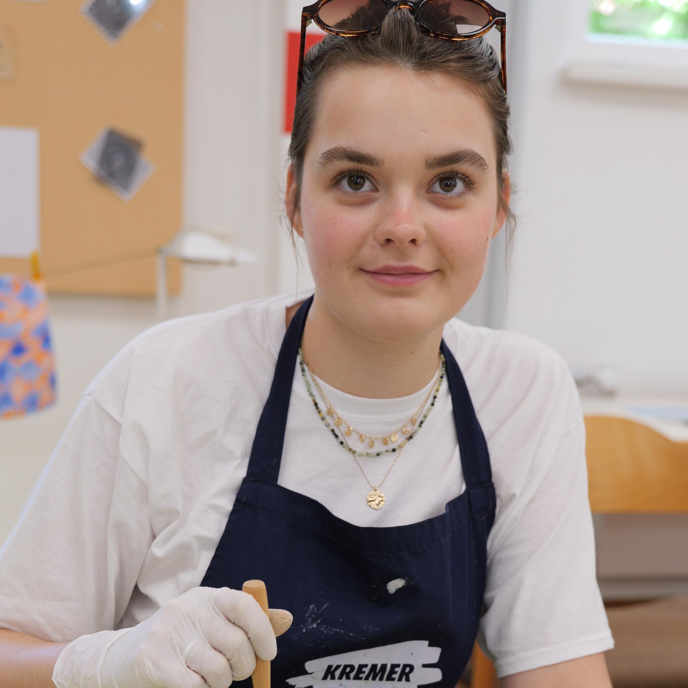 Junge Frau zieht Papier mit Marmormuster aus einer Schale