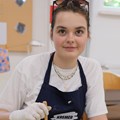 Junge Frau zieht Papier mit Marmormuster aus einer Schale