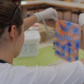 Junge Frau zieht marmoriertes Papier aus Farbschale
