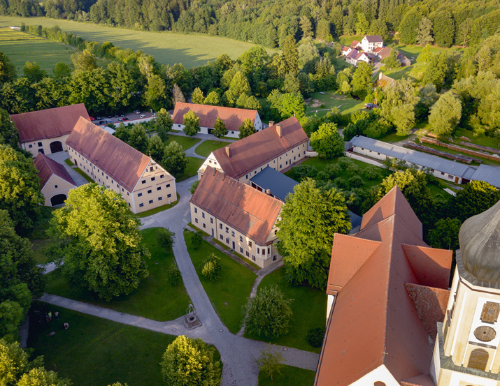Museumsgebäude eingebettet in Wiesen und Wald, aus der Luft fotografiert