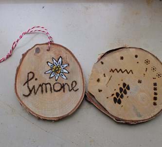 Zwei kleine Baumscheiben mit eingebranntem Muster und Namen: Simone