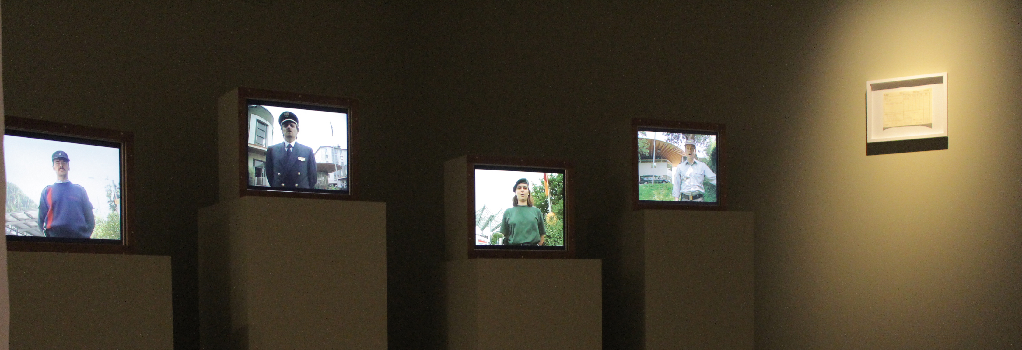 Vier Monitore mit Portraits von Grenzbeamten aus vier Ländern