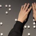 Finger ertasten weiße Elemente in Braille-Schrift